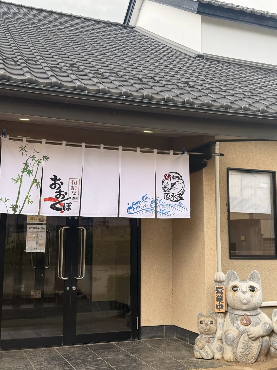 旬割烹寿司おおくぼの店舗外観。瓦屋根と暖簾、招き猫が出迎える入口