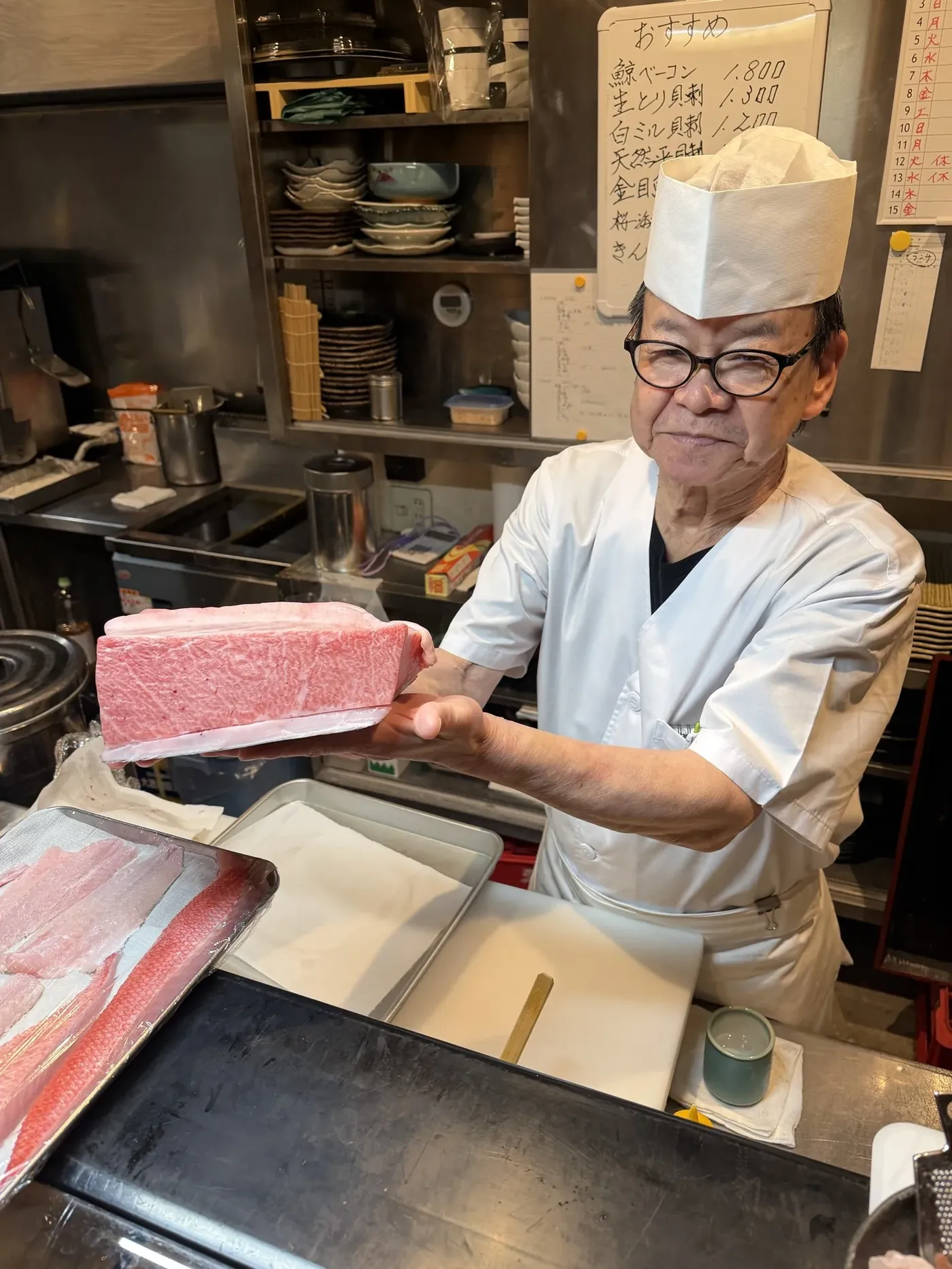 原水産から届いた本マグロのサクを手にする店主